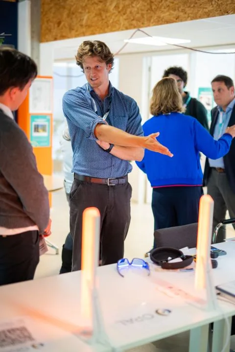 Florian legt bezoekers uit hoe de OPAL Energy Bars werken, bij PLNT Leiden